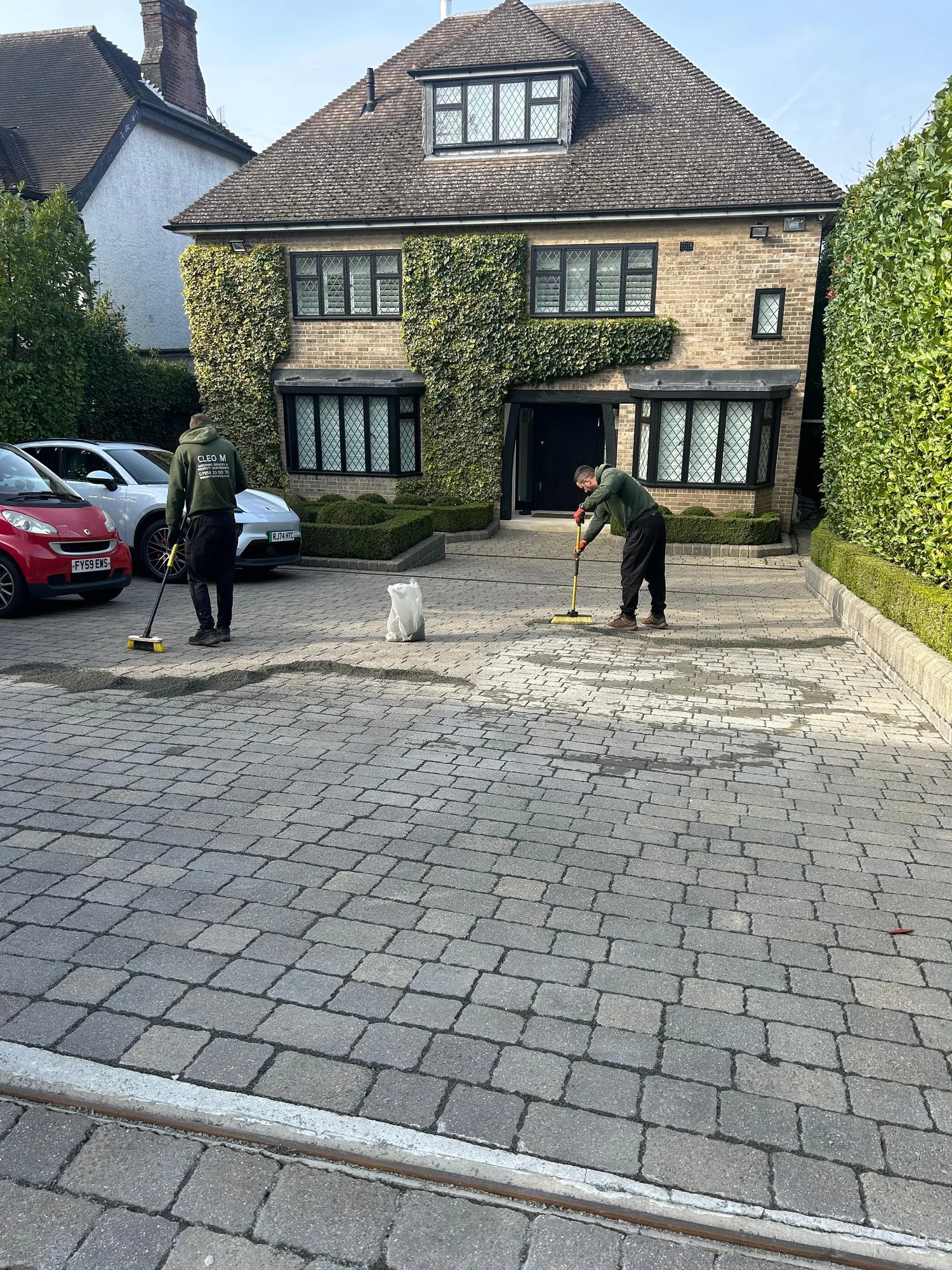 Mill Hill NW4 driveway with workers sweeping in joint-filling aggregate